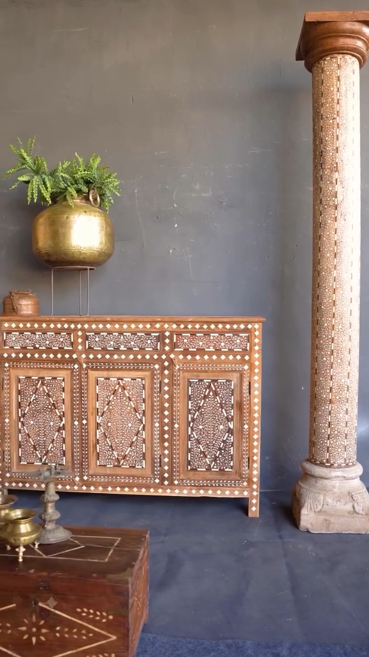 Bone-inlay wooden cabinet, carved pillar and brass planter styled for a vintage furniture shoot